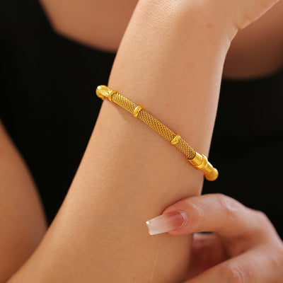 Gold bamboo mesh bracelet worn on wrist