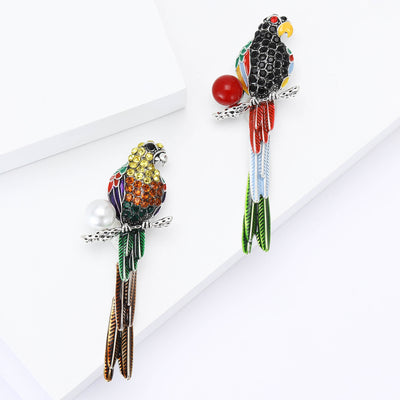 Product display showing a crystal parrot beside a red bead with long beaded tail strands