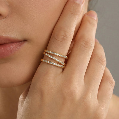 Gold triple pave open ring worn on index finger near face