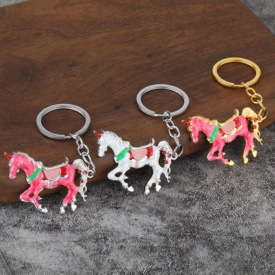 Three unicorn keychains in pink and white body colors with silver-tone and gold-tone hardware.