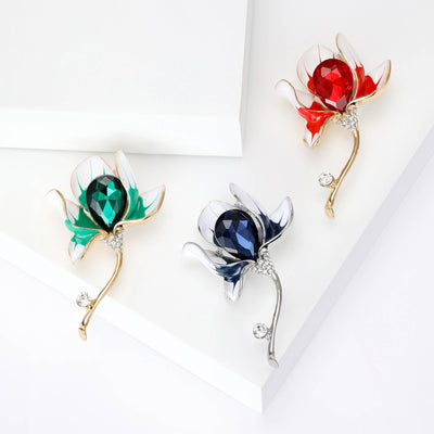 Blue Flower, Red Flower, Green Flower brooch styles arranged on a light display