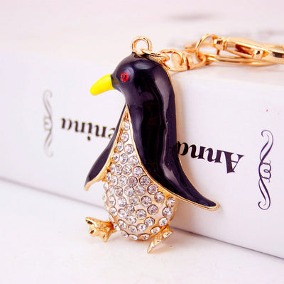 Close view of a black penguin keychain resting against a white box