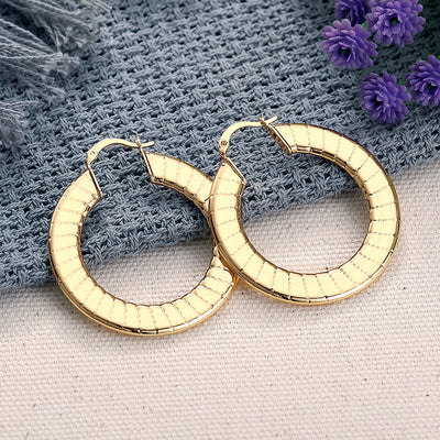 Gold flat wide ribbed hoops on linen with purple tassels