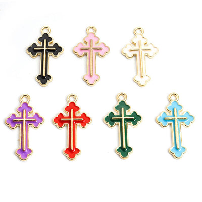Assorted cross charms arranged on a white surface