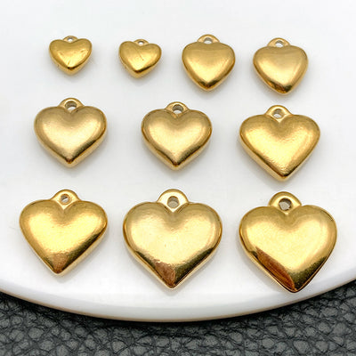Gold-tone heart charms arranged on a light background