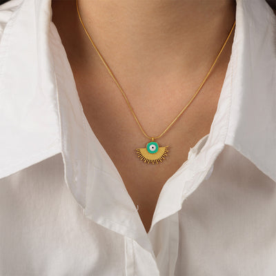 Green enamel evil eye fan pendant necklace worn with white shirt