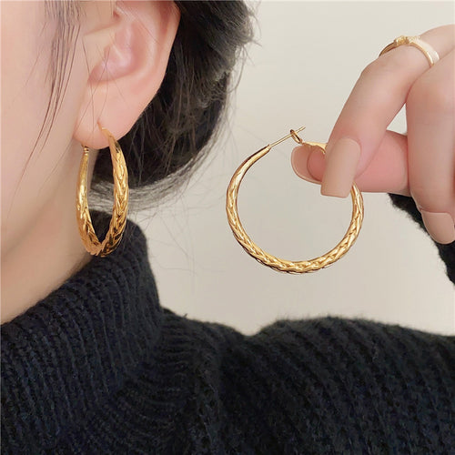Main image 2 showing medium gold-tone hoops with a braided raised texture and rounded profile, arranged detail view