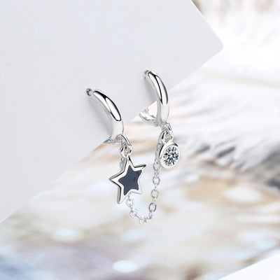 Silver double huggie earrings with black star and clear stone on white card