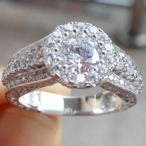 Styled view showing a round halo center with pierced scrollwork sides