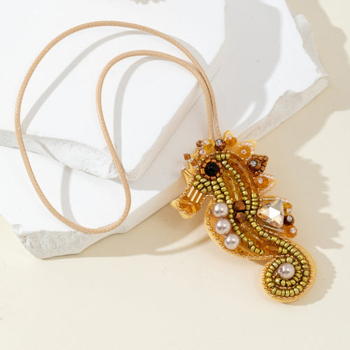 Close-up of the seahorse pendant's beaded scales and pearl details