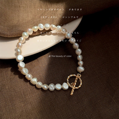 Irregular-white-pearl bracelet with gold-tone toggle in the first product display.