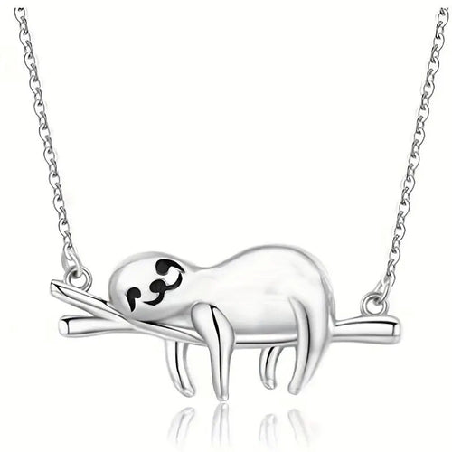 White metal sloth branch pendant close-up on reflective surface