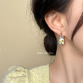Silver Tone Oval Frame White Flower And Green Leaf Stud Earrings view 2