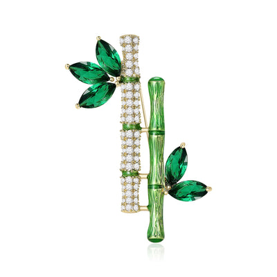 Front view of twin bamboo stem brooch with clear crystals and green marquise leaves against a white background.