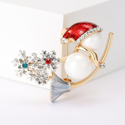 A pearl-bodied snowman beside a crystal evergreen tree shown on a white background.