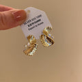 Gold Tone Textured Fan Twist Stud Earrings with Crystals view 1