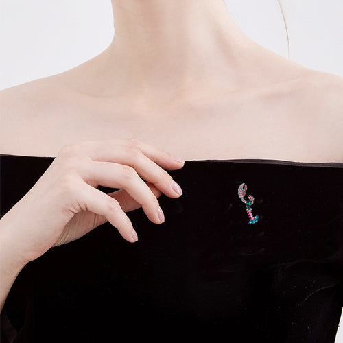 Lobster brooch worn on black off-shoulder neckline