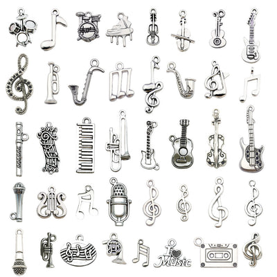 Antique silver musical instrument charms arranged on a light background