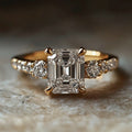Emerald-Cut Clear Solitaire Ring With Round Side Stones In Gold Tone view 5