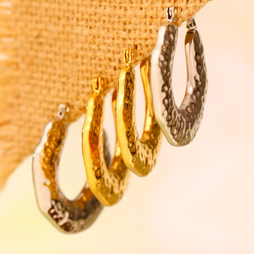 Gold and steel textured U hoops hanging on burlap