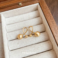 Gold Tone Polished Orb Stud Earrings with Crossing Loops view 2