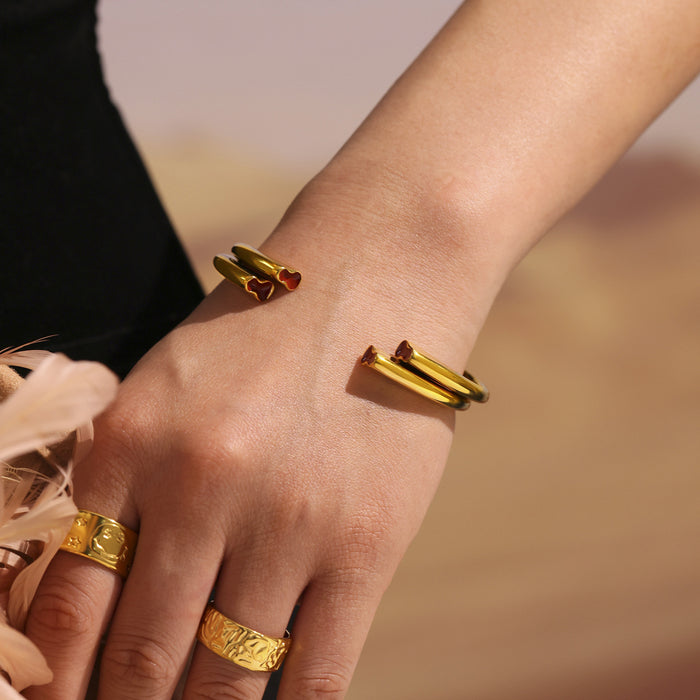 Open Cuff Bracelet With Heart Ends In Gold And Steel Tone