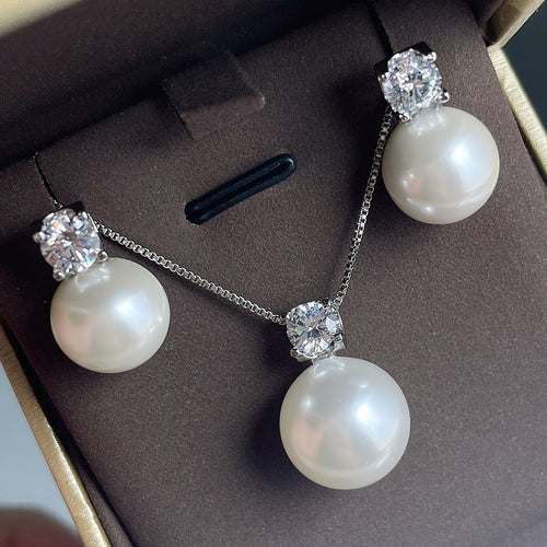 Silver pearl stud earrings and matching pendant necklace in brown box