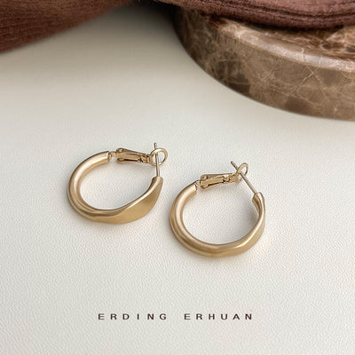 Matte light coffee brown geometric hoop pair on white with marble prop