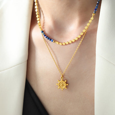 Gold disc bead and blue stone necklace layered with ship wheel pendant