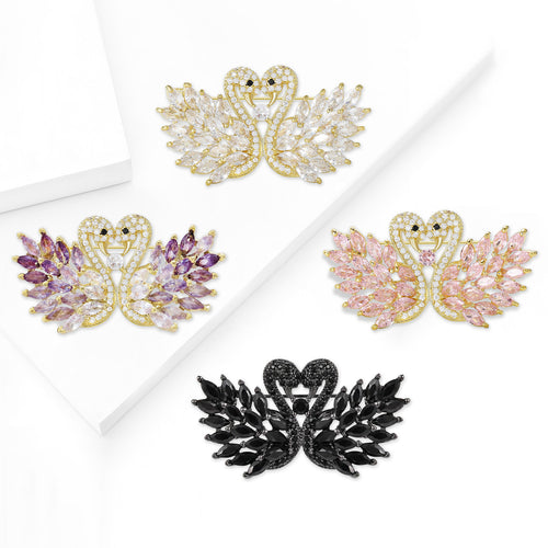 Angled view showing the double swan brooch surface