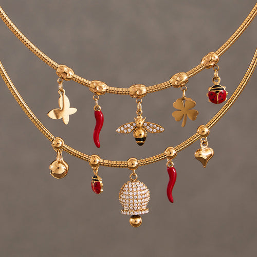 Close-up of gold bee chili clover ladybug and pavé bell charms on chains