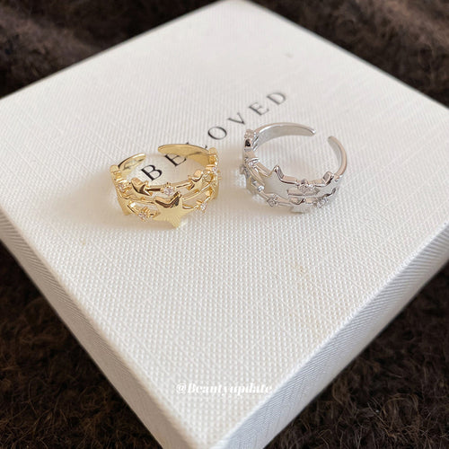 Gold and silver open star rings on white box