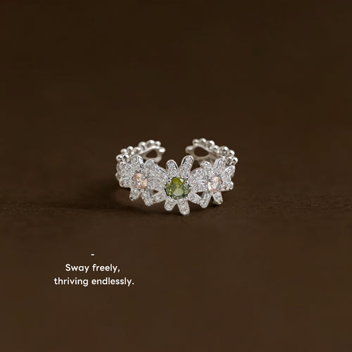 Silver-tone clear-stone-daisy green-center open ring in the first product display.