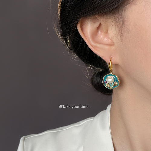 Teal enamel pearl disc earring worn on ear side profile