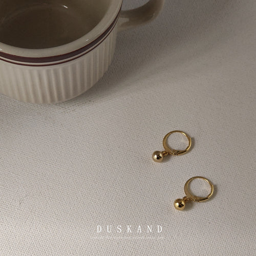 Gold-tone small-ball-charm huggie hoops in the first product display.