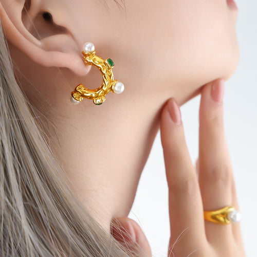 Gold textured C earring with pearls and green stones worn side view