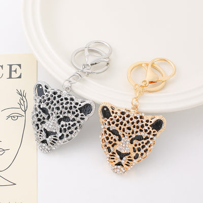 Silver and gold rhinestone leopard head keychains on white plate