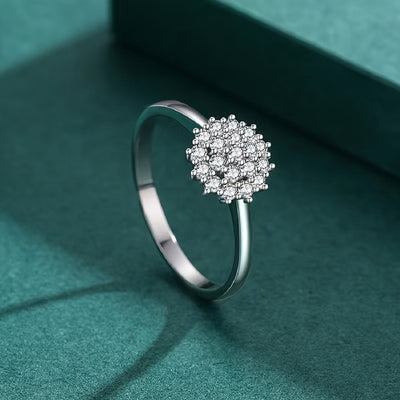 Silver snowflake CZ cluster ring on green surface