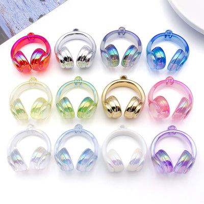 Iridescent headphone charms arranged on a light background