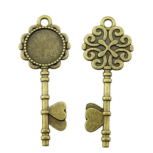 Key Shaped Round Cabochon Pendant Trays in Two Finishes shown in image 1 with a key silhouette and scrollwork reverse
