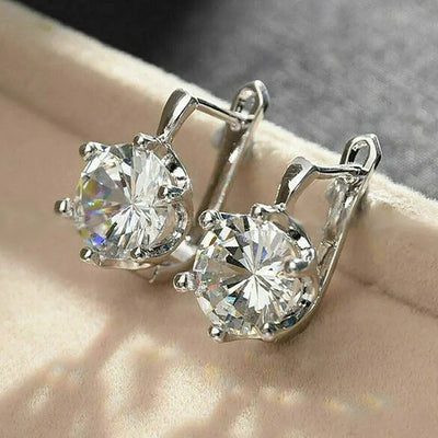 Pair of silver lever-back round clear CZ earrings on beige velvet