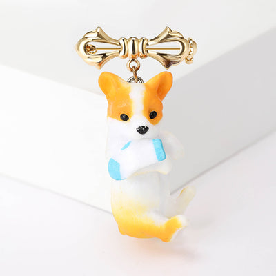 Front view of the orange and white dog brooch with bow with polished metal detail on a white background