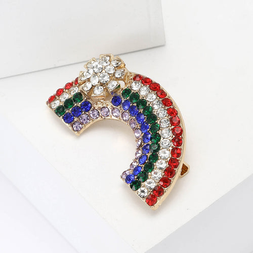 Rainbow multicolor rhinestone brooch angled on white block