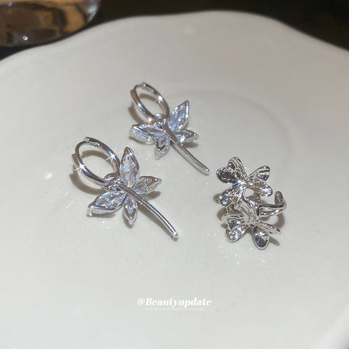 silver tone crystal floral earrings and pendant necklace assortment shown in an on-ear styling view