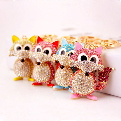 Four gold-tone rhinestone fox keychains in pink, blue, red, and gold colors.