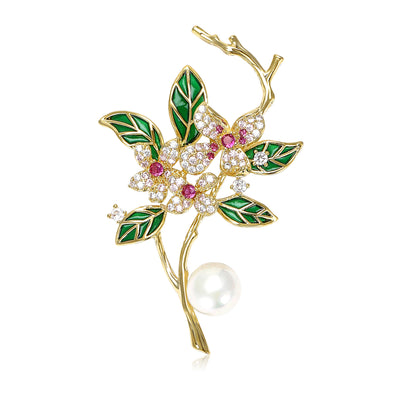 Front view of green flowering branch brooch with pearl against a white background.