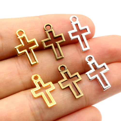 Grouped front view of openwork cross metal charms in gold bronze and silver tones