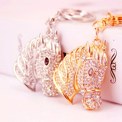 Gold-tone and silver-tone rhinestone horse head keychains shown together.