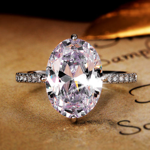 Silver-tone large oval clear CZ solitaire ring on parchment