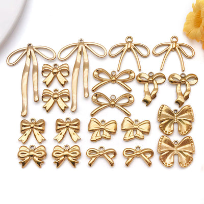 Gold-tone bow and butterfly charms arranged on a light background